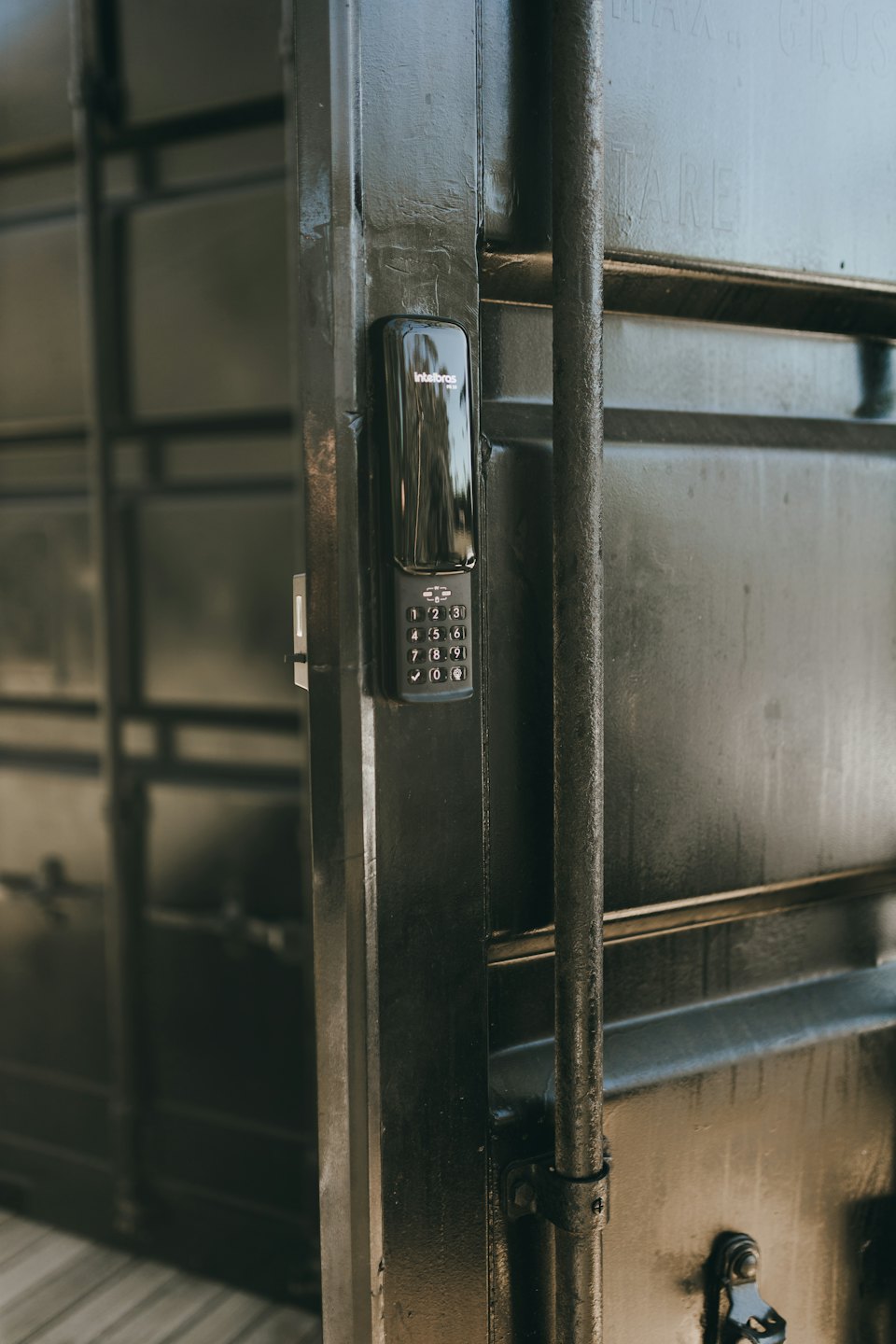 Tastierino digitale nero su una porta di sicurezza in metallo scuro.