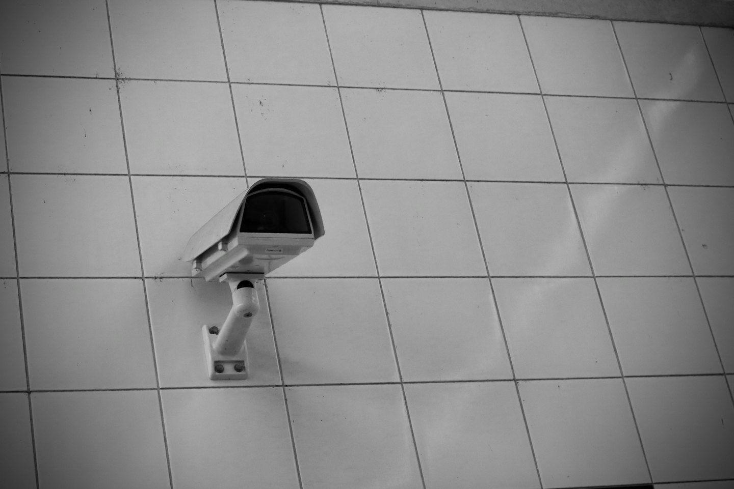 Telecamera di sicurezza montata su una parete piastrellata.